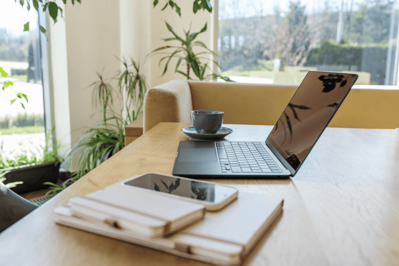 A laptop and coffee on a table in a bright room